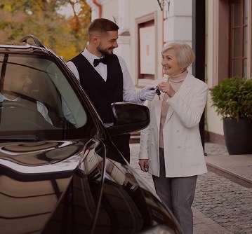 Парковщик ресторана принимает ключи от автомобиля гостьи
